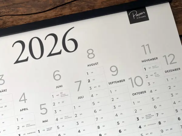 Detailaufnahme des Jahreskalenders 2026 aus Apfelpapier in DIN A1 mit Monatsübersicht und schwarzer Magnet-Posterleiste.
