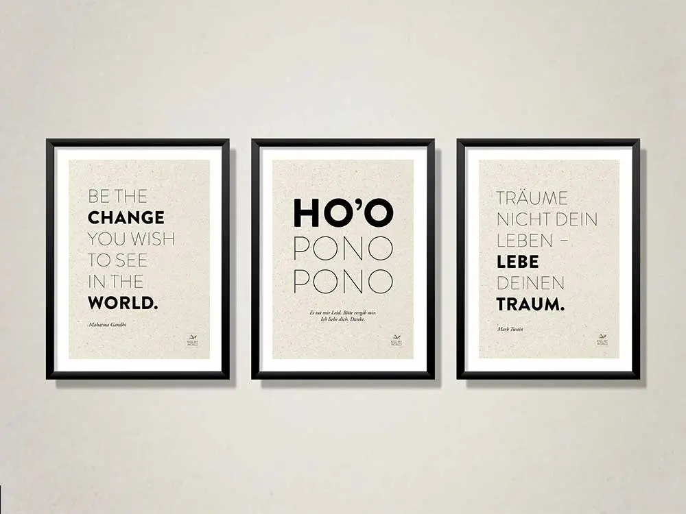 Drei gerahmte Poster mit Sprüchen auf Graspapier an einer hellen Wand