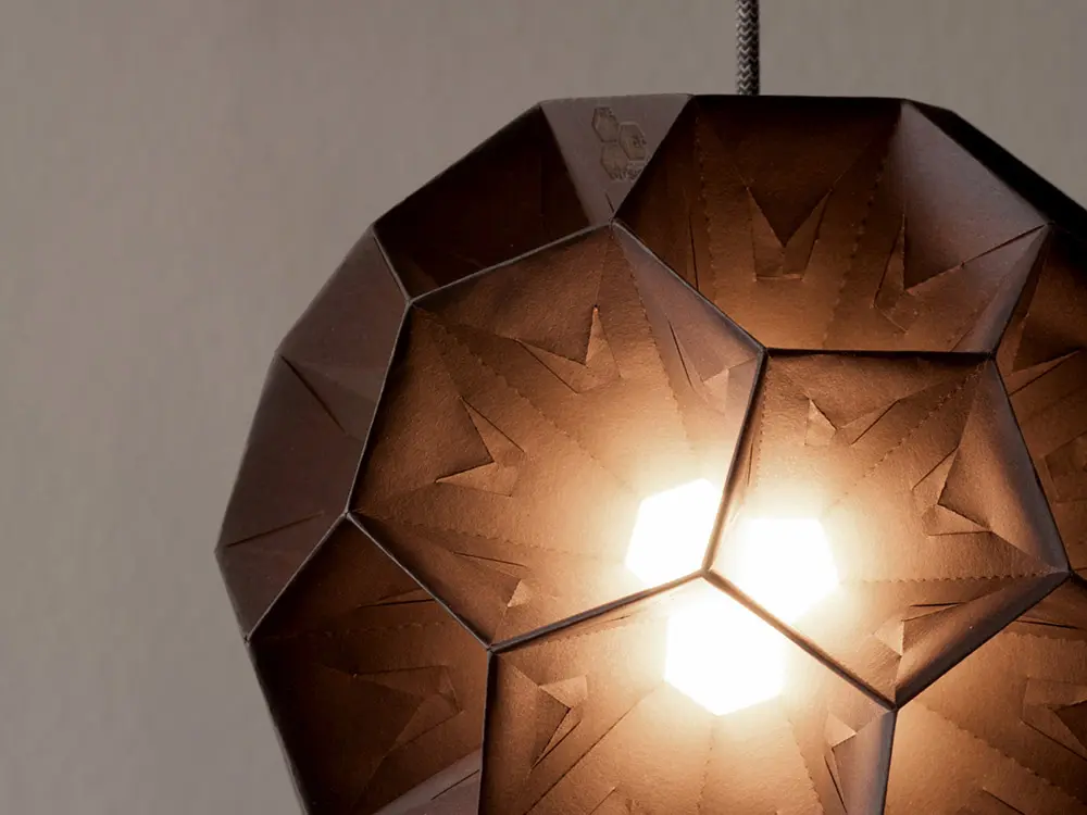 Nahaufnahme einer Papierlampe in Kaffeebraun mit Leuchteffekt