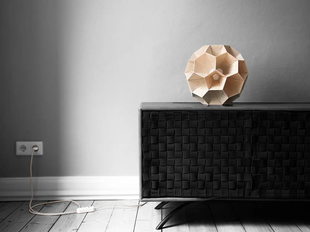 Moderne geometrische Papierleuchte von Bernd Görtz auf einem Sideboard bei Tageslicht