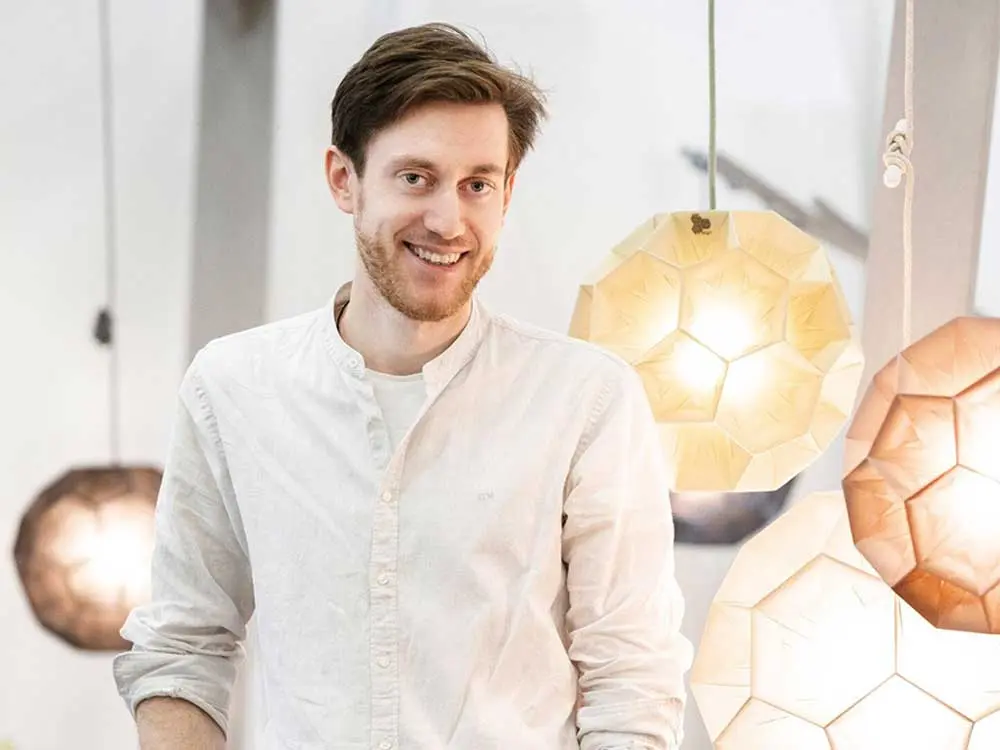 Unser Workshop-Leiter und Handwerksdesigner Bernd Görtz mit gefalteten Papierleuchten aus Naturpapier im Hintergrund