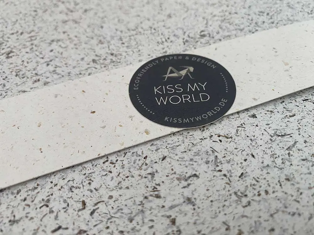 Nahaufnahme einer naturfarbenen Banderole mit Papier à la Carte Logo auf Notpla Algenpapier