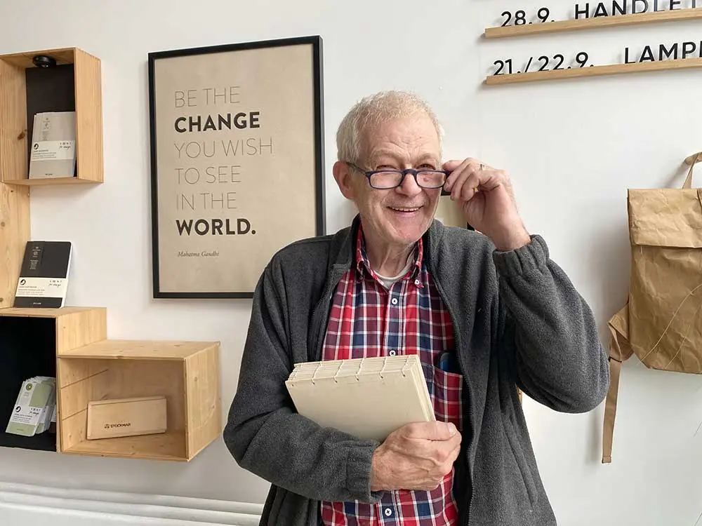 Porträt von Dietmar Mohnke im Papier à la Carte Showroom mit einem handgebundenen Buch in der Hand.