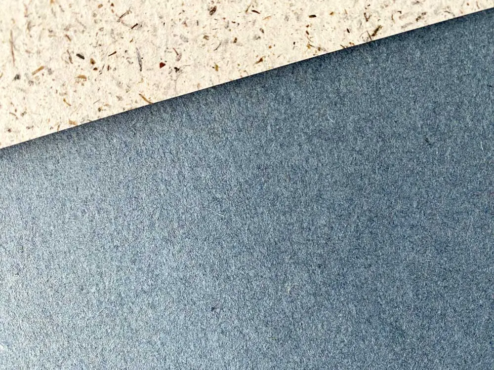 Papier à la Carte_Jeanspapier_Jagotech_04 Strukturaufnahme von Jeanspapier mit sichtbarer Banderole aus Recyclingpapier, Detailaufnahme / Nahaufnahme des umweltfreundlichen Jeanspapiers. Das Papier à la Carte-Jeanspapier im Format A4 ist von Jagotech und es wird aus Abschnitten hergestellt, die bei der Jeansproduktion übrigbleiben. Du kannst das Jeanspapier kaufen und als Bastelpapier, Künstlerpapier, Zeichenpapier, Skizzenpapier oder zum Malen benutzen.